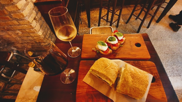 Panino, bruschette e vino su un tavolo del locale
